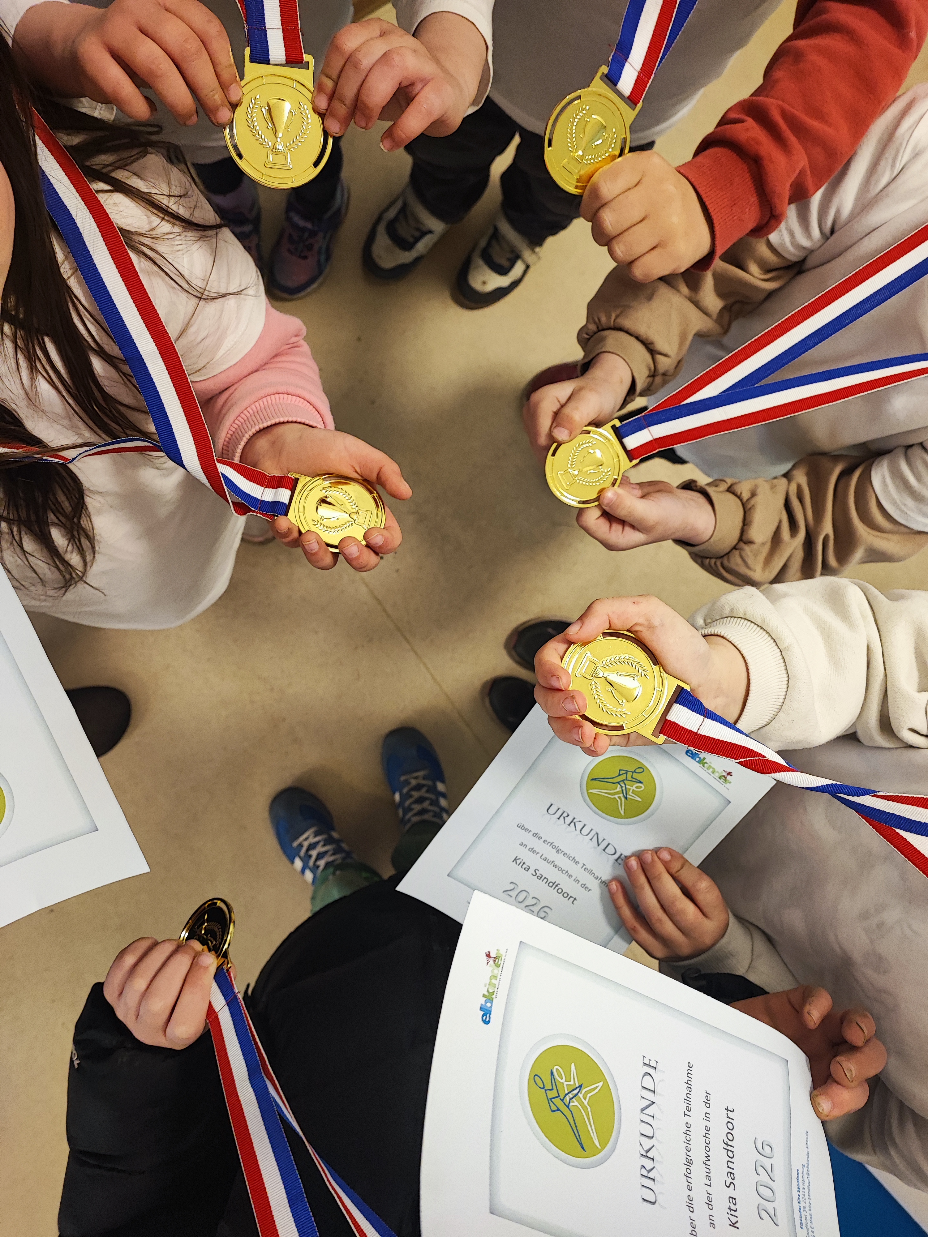Kinder mit Medaillen und Urkunde der Kita-Laufwoche